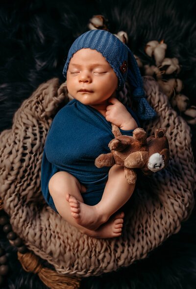 Newborn baby wrapped in blue for his photo session