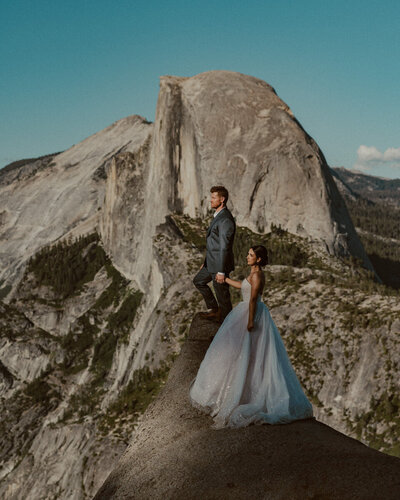 bride and groom at glacier point with half dome in the background