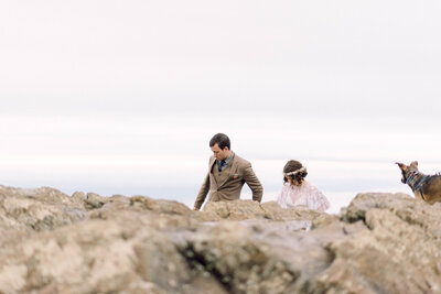 Bride and groom standing hand in hand with a mountain lake behind them during their intimate Virginia elopement, photographed in natural light and soft tones.

