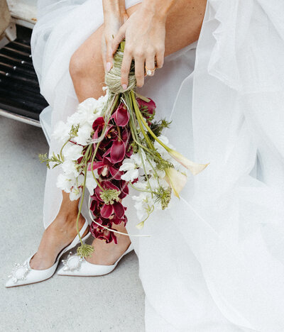 Bride holding a loose, romantic bouquet with white and blush flowers