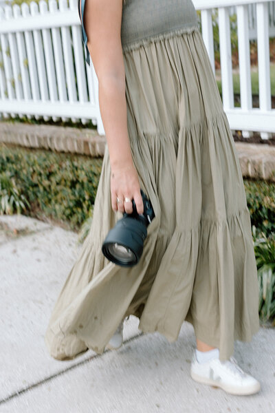 Caroline Keown, photographer, walks by holding her camera.
