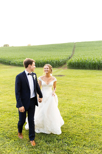 Bride and groom walking along in a field at the Ruby Cora, Tennessee
