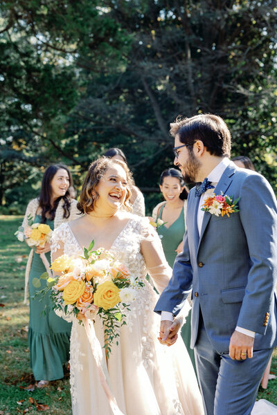 Bride and groom holding hands while looking at each other