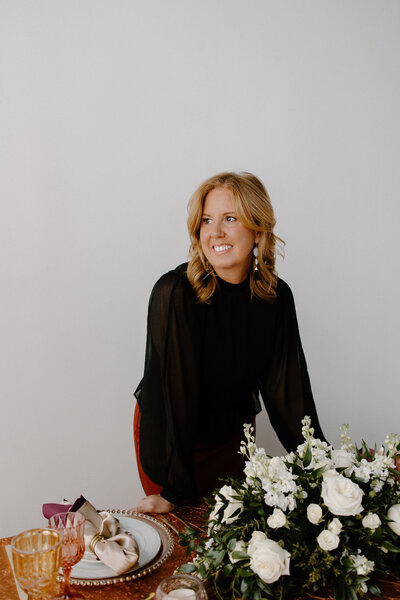 woman standing at table next to white flowers