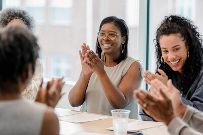Leader attentively listening and applauding during a team meeting.