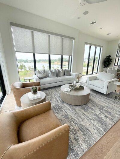 A living room designed by interior design experts in Frisco, TX, featuring vintage accessories and a large grey carpet for a cozy and stylish atmosphere.