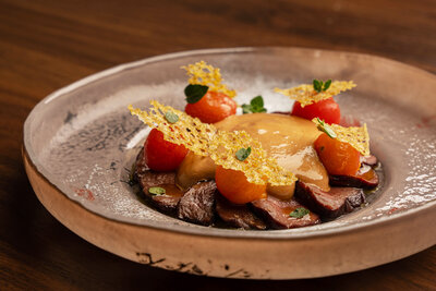 Seared venison with cherry tomato, oregano, and black garlic zabaglione at Revé