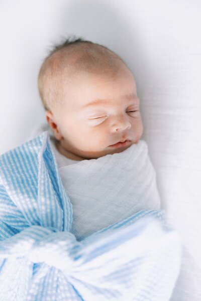 close up photo of baby boy wrapped in searsucker bow during newborn session