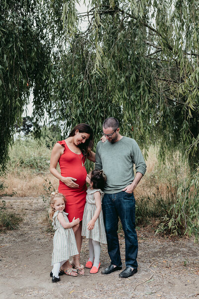 Maternity Photographer,  a young family huddles around mom, she is expecting