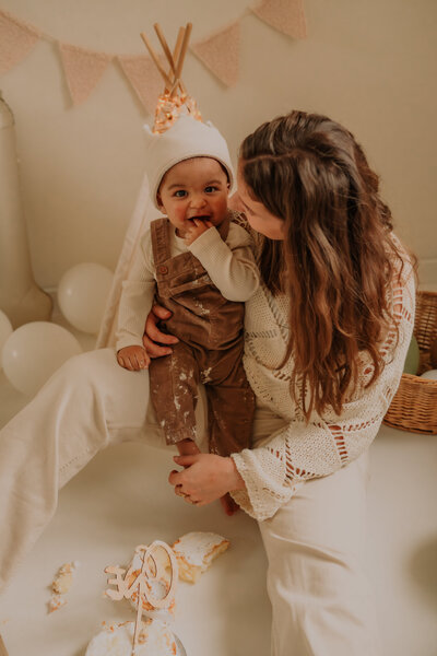 Mama kijkt zoontje aan tijdens cakesmash shoot