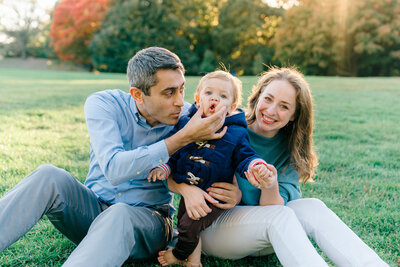 a family sits with their kids in central park