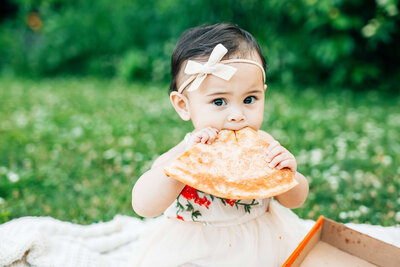 baby eating pizza outdoors