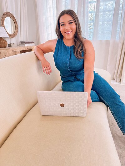 Natalie sitting on a couch with her laptop