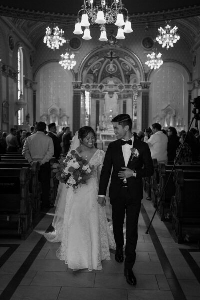 Catholic bride and groom recess up aisle after wedding ceremony