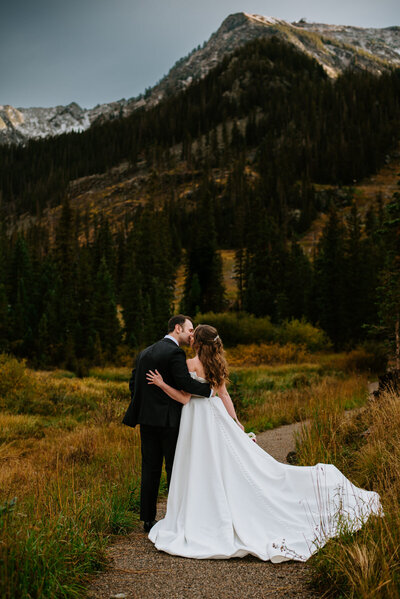 Newlyweds cuddle and look out into the mountains after their Elopement in Dillion, Colorado