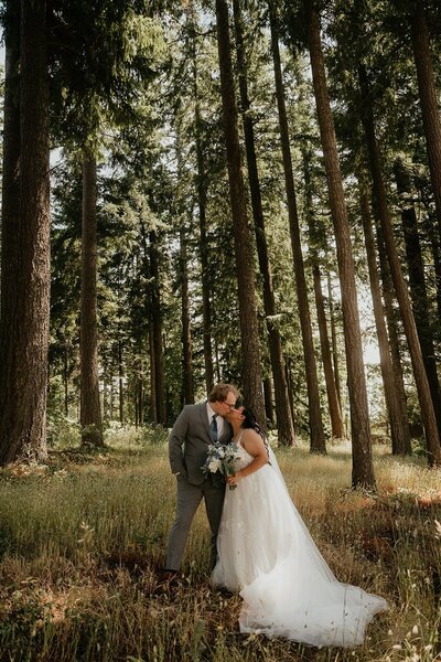 Bride and groom kiss in the forest during their elopement in Oregon