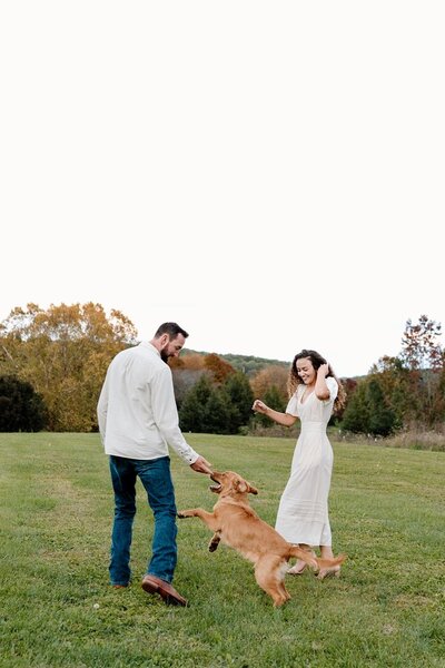candid moment of couple playing with their dog at charlottesville wedding venue
