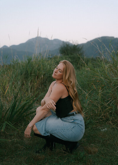 Portrait of Rae Terrillon, Vancouver Island portrait photographer, smiling amidst natural surroundings.