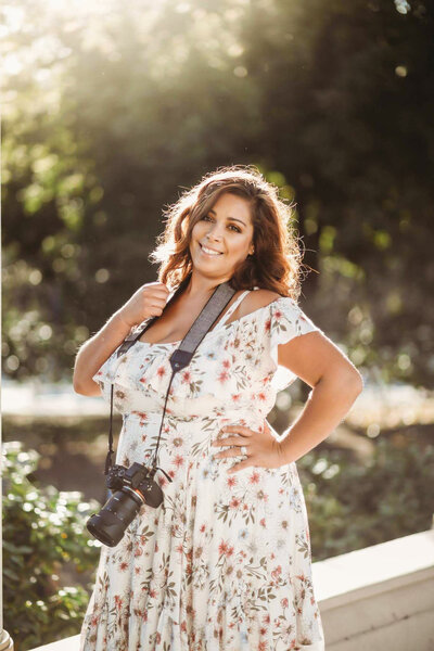 Female photographer posing with her camera