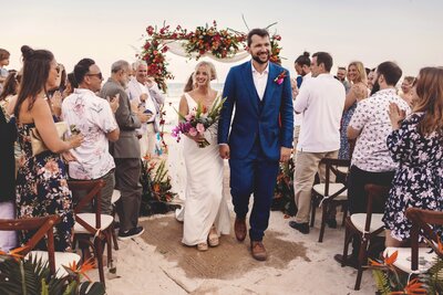 Bride and Groom laughing on together on beach after wedding in Riviera Maya