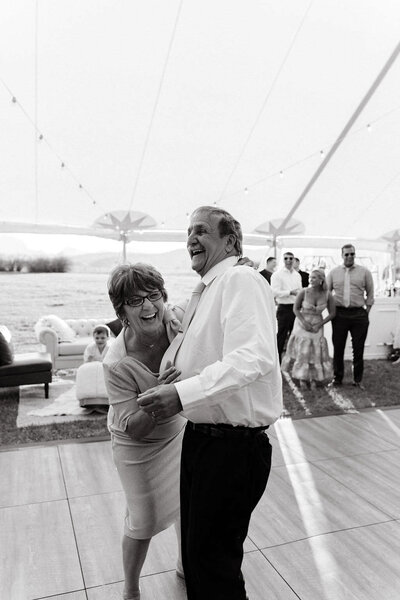 man and woman dancing together on reception dance floor while laughing
