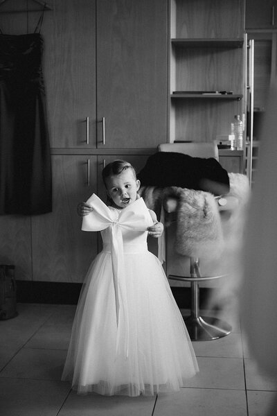 Candid of flower girl admiring the huge bow that will go in her hair 