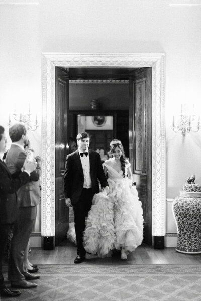 Luxury wedding at Somerley House with a Chinese bride in a Sally Bean dress and Jewish groom, embracing under a large tree in a garden.