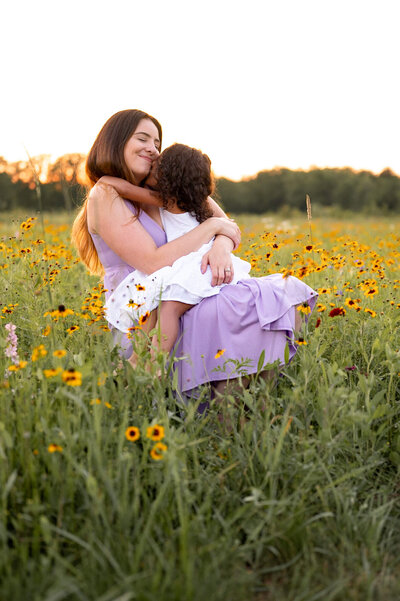 Mom holding daughter in field of flowers in a Canton Park