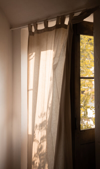 Tan curtains with the sun shining through 