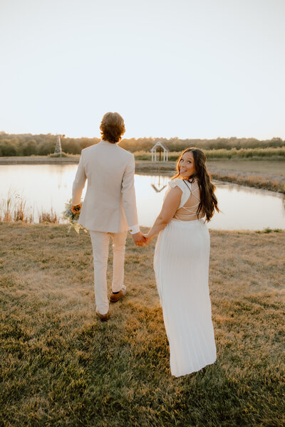 couple walking and holding hands during lakeside elopement in missouri