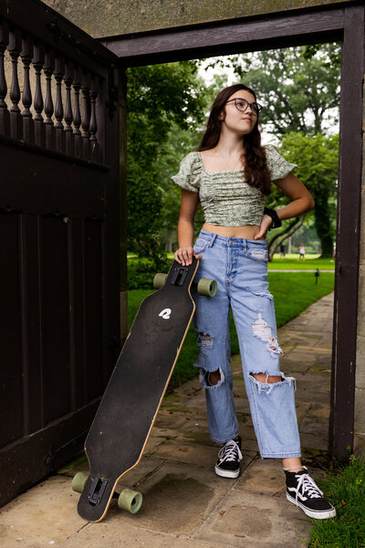High school senior girl with skateboard.