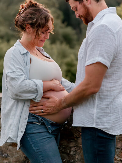 a couple embracing the pregnant belly of the woman during an outdoor photo session