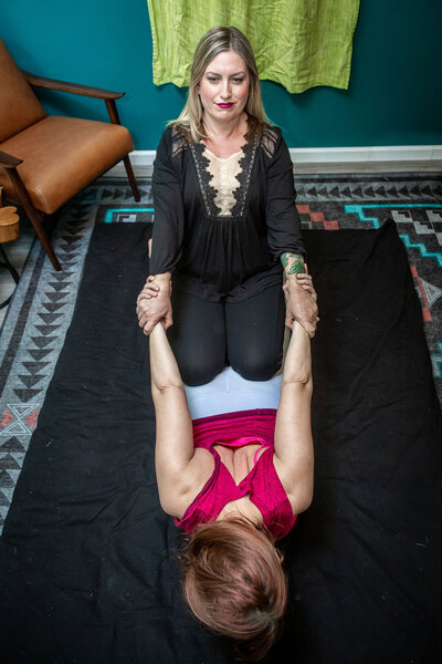 Women on floor Thai massage back stretch