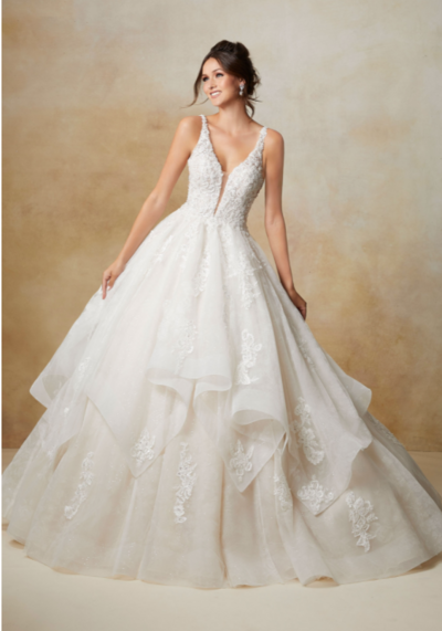 Stunning Tulle Ballgown Accented in Delicate Beaded Embroidery. The Plunging, Off-the-Shoulder Neckline and Delicately Beaded Illusion Sleeves add a Touch of Romance. Covered Button Details Along the Back and a Wide Horsehair Hemline Complete the Look. Available in Three Lengths: 55″, 58″, 61″. Shown in Ivory/Nude