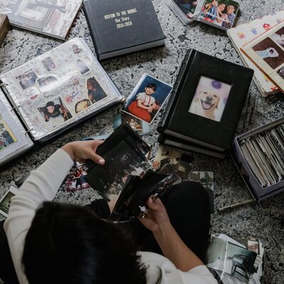 Kiera Liu sitting on the floor looking at yearly photo books