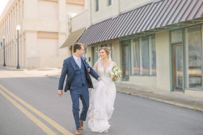bride and groom walking in the street in a downtown area