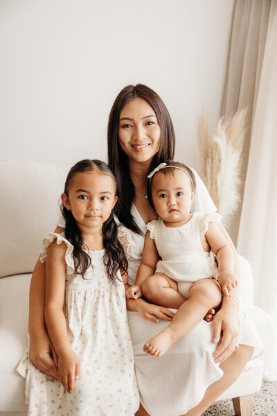 Family portraits of a little boy holding his nerborn baby sister in michelle kelly's photography studio