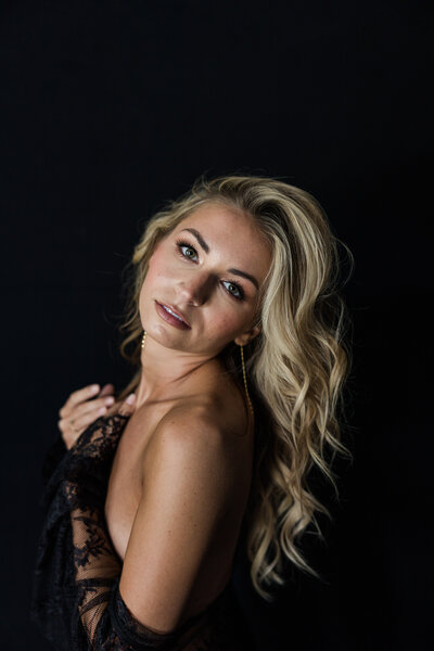 Smiling woman feeling empowered during a professional boudoir photo shoot 