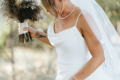 bride holding her dress and bouquet