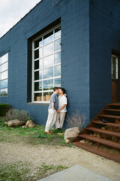 Intimate couples photography of couple leaning against the side of a building in embrace