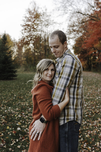 Verona B Photography captures a beautiful fall family photo of a Husband and wife embracing at Silver Creek Metro Park in Norton, OH. The man is looking down at his wife while she smiles at the camera. It was so wonderful to capture this family in this beautiful fall setting near Akron.