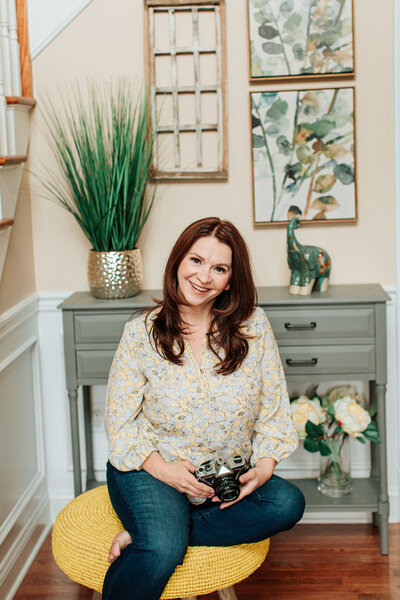 photo of top nj newborn photographer posing in her home holding a camera and smiling