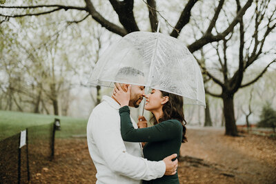 Couple cuddling under an umbrella