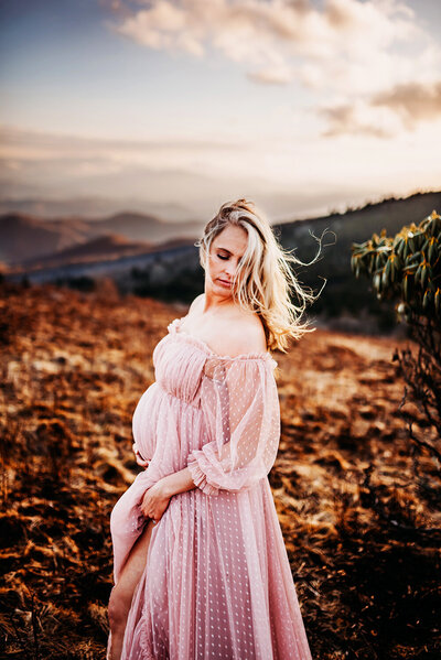 beautiful pregnant mama on a mountain top with the wind blowing through her hair