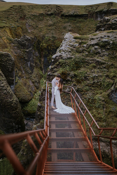  Intimate elopement kiss above a moss-covered Icelandic canyon, captured in a breathtaking location by an Iceland wedding photographer.