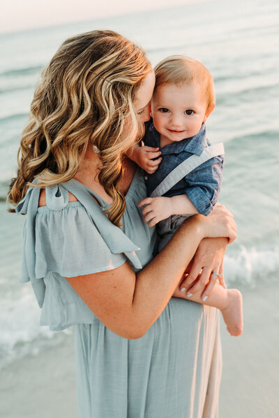 Family Photographer, a pregnant mother stands at the tides edge
