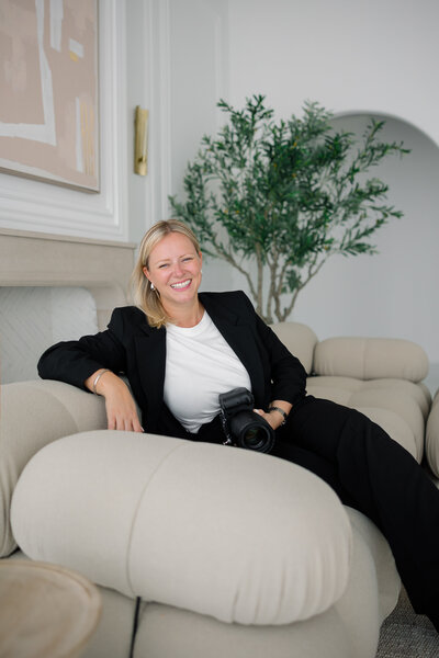 Jessica van der Marel - owner of Portraits by JEROZA headshot sitting on wooden barstool