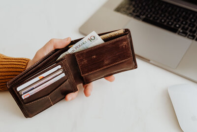 kaboompics_closeup-man-hand-open-brown-genuine-leather-wallet-with-banknote-and-credit-cards-on-marble-background-with-clipping-path-15054