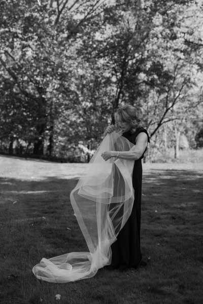 A person holding a veil and straightening it out 