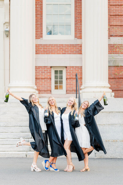 Group of four grads in gowns at Worcester State University taken by best college grad photographer in Worcester, MA